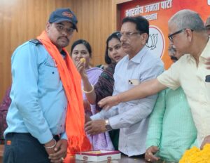 कर्मचारियों का पटका पहनाकर करते हुए ।